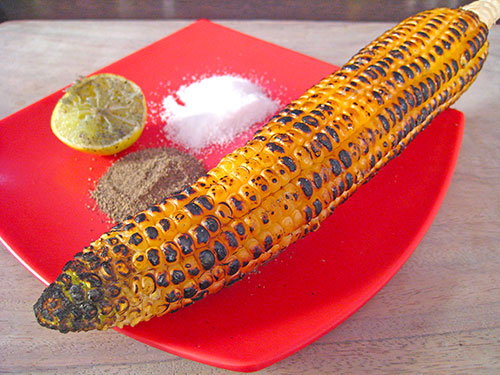 Roasting of corn and apply salt, black pepper and lemon